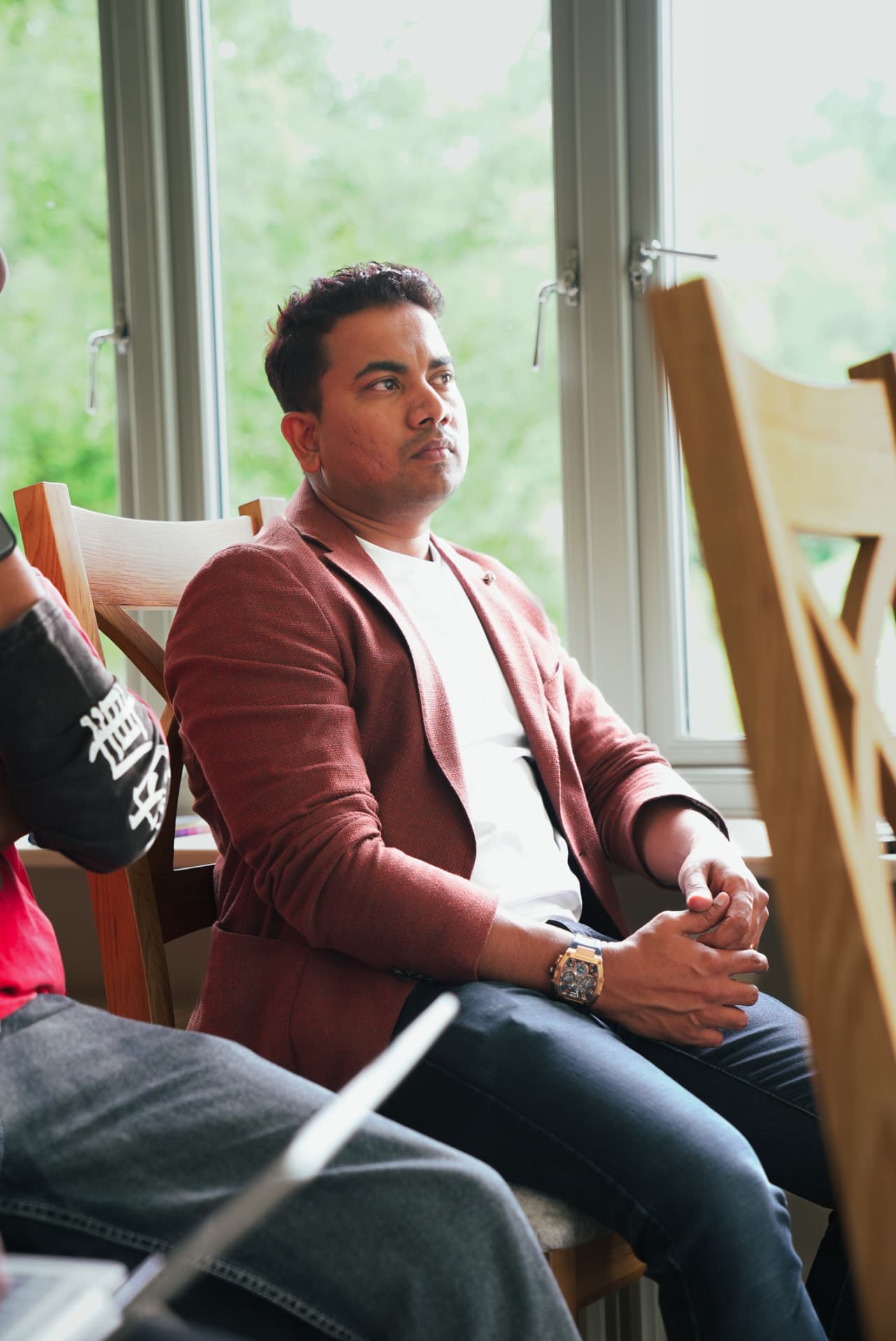 A member seated by the window during a meetup discussion