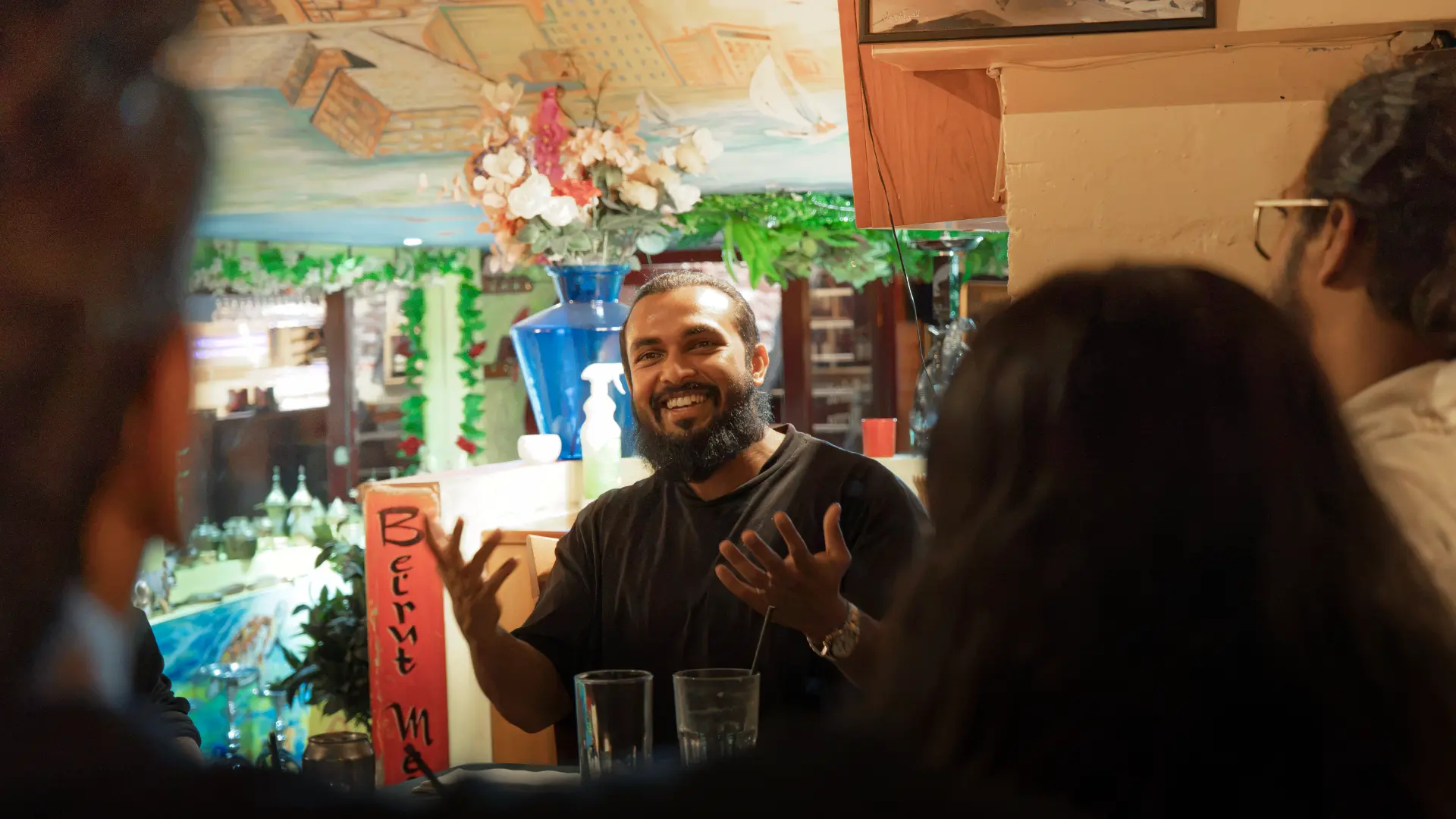 A member telling a story to the table over drinks at a meetup