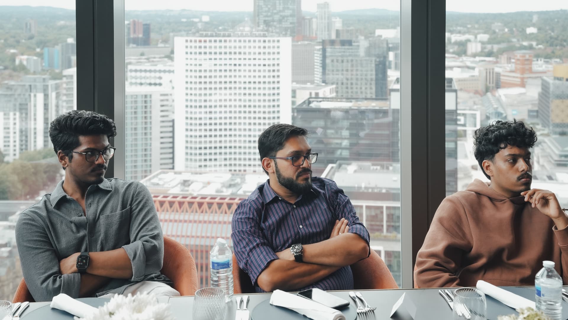 Members deep in thought over a city skyline at a meetup