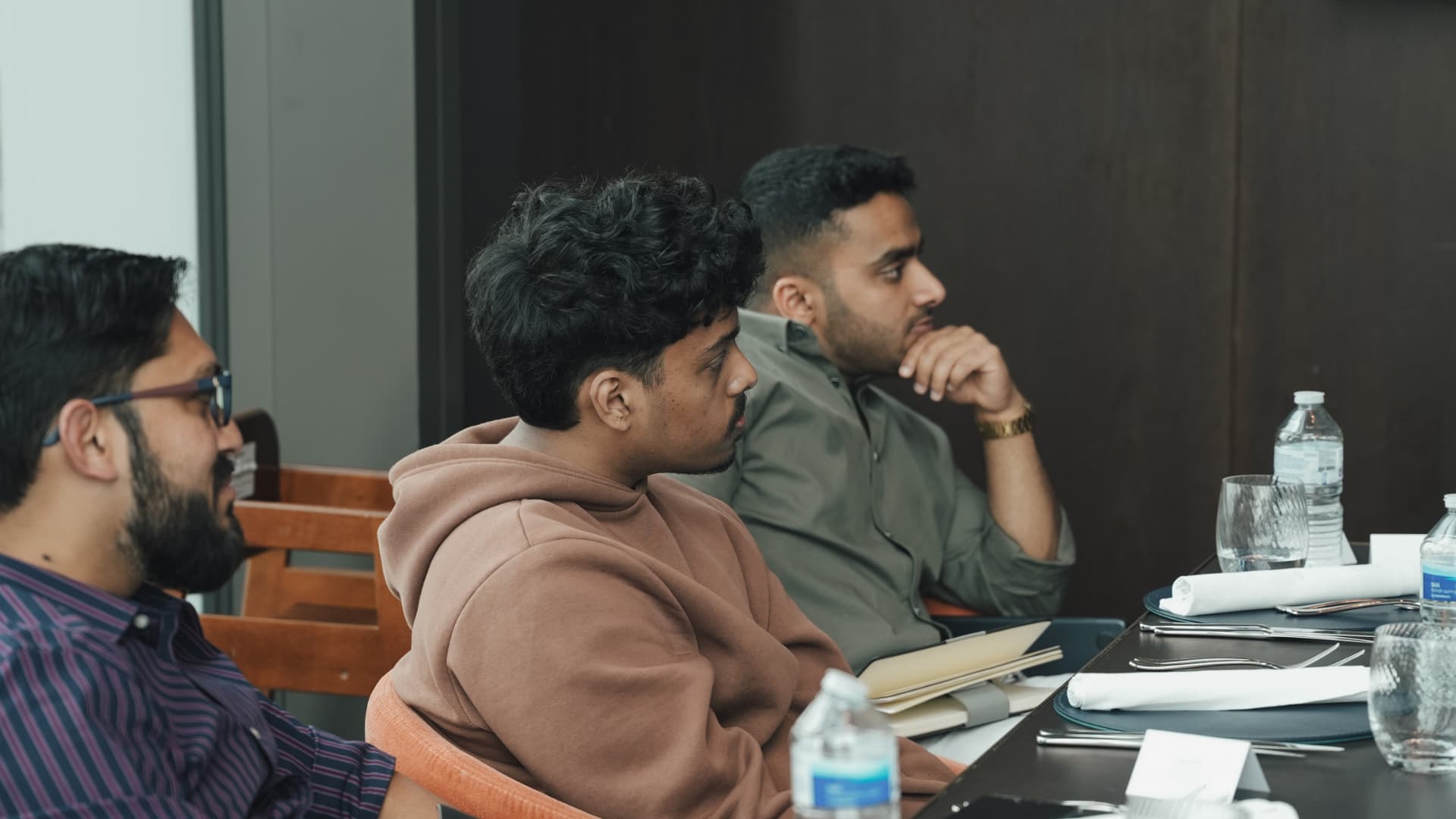 Members listening intently around the table at a meetup