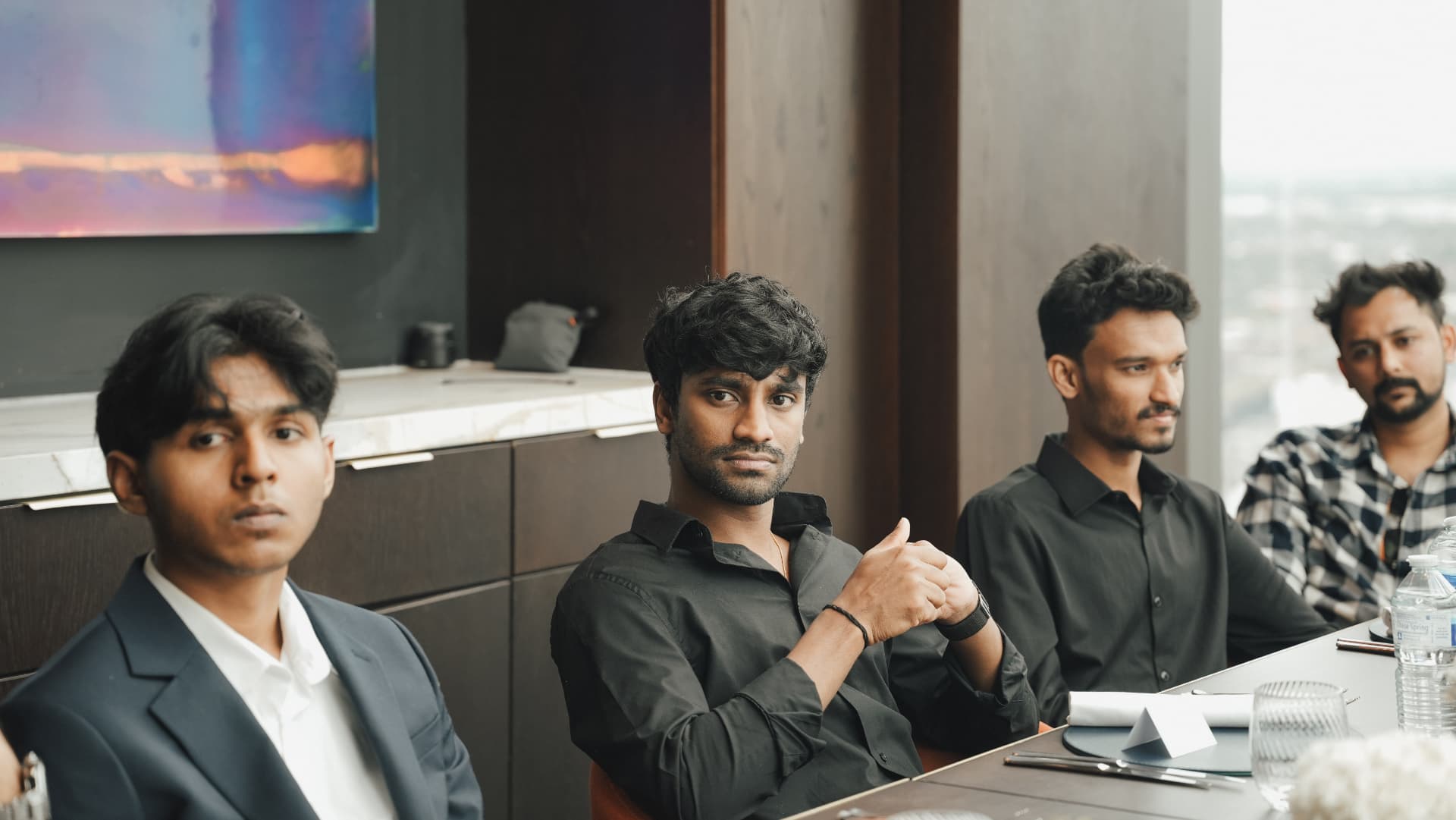 Members listening around a table during a monthly meetup