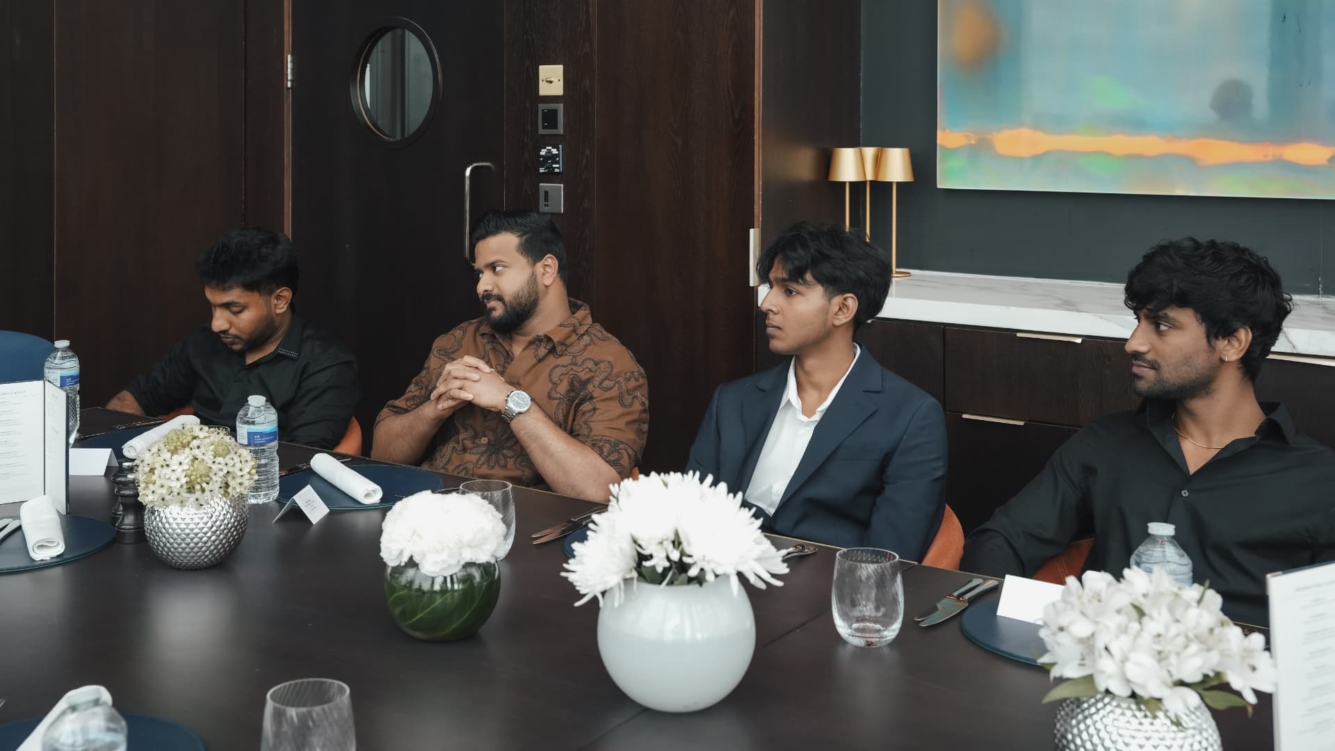 Members listening around the table during a mastermind dinner