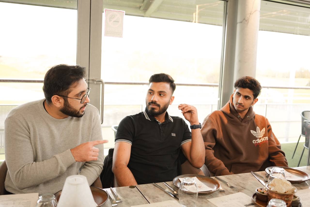 Three members talking over dinner at a community experience