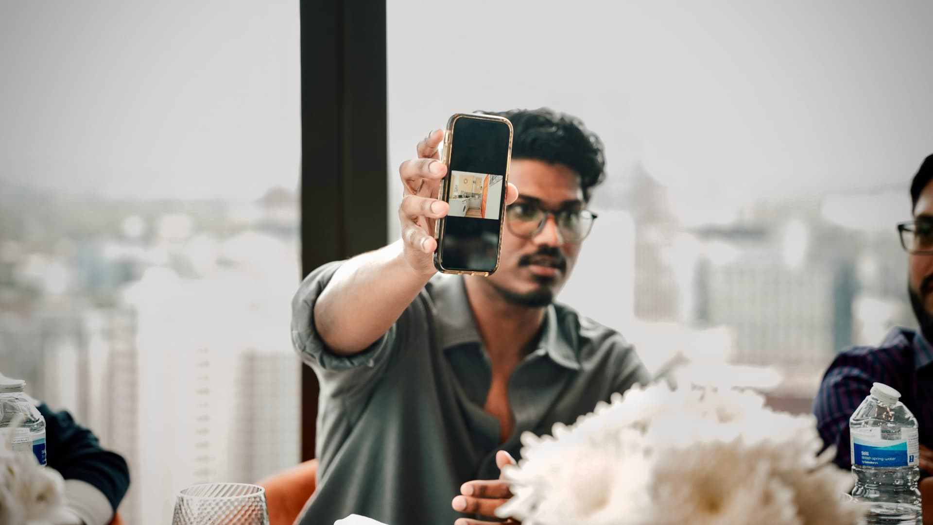 A member holding up a phone to show a property photo at a meetup