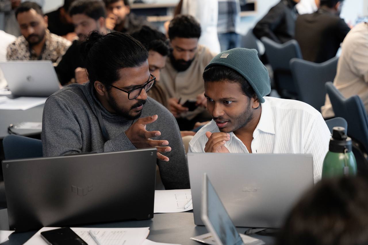 Members in deep discussion over their laptops at a workshop