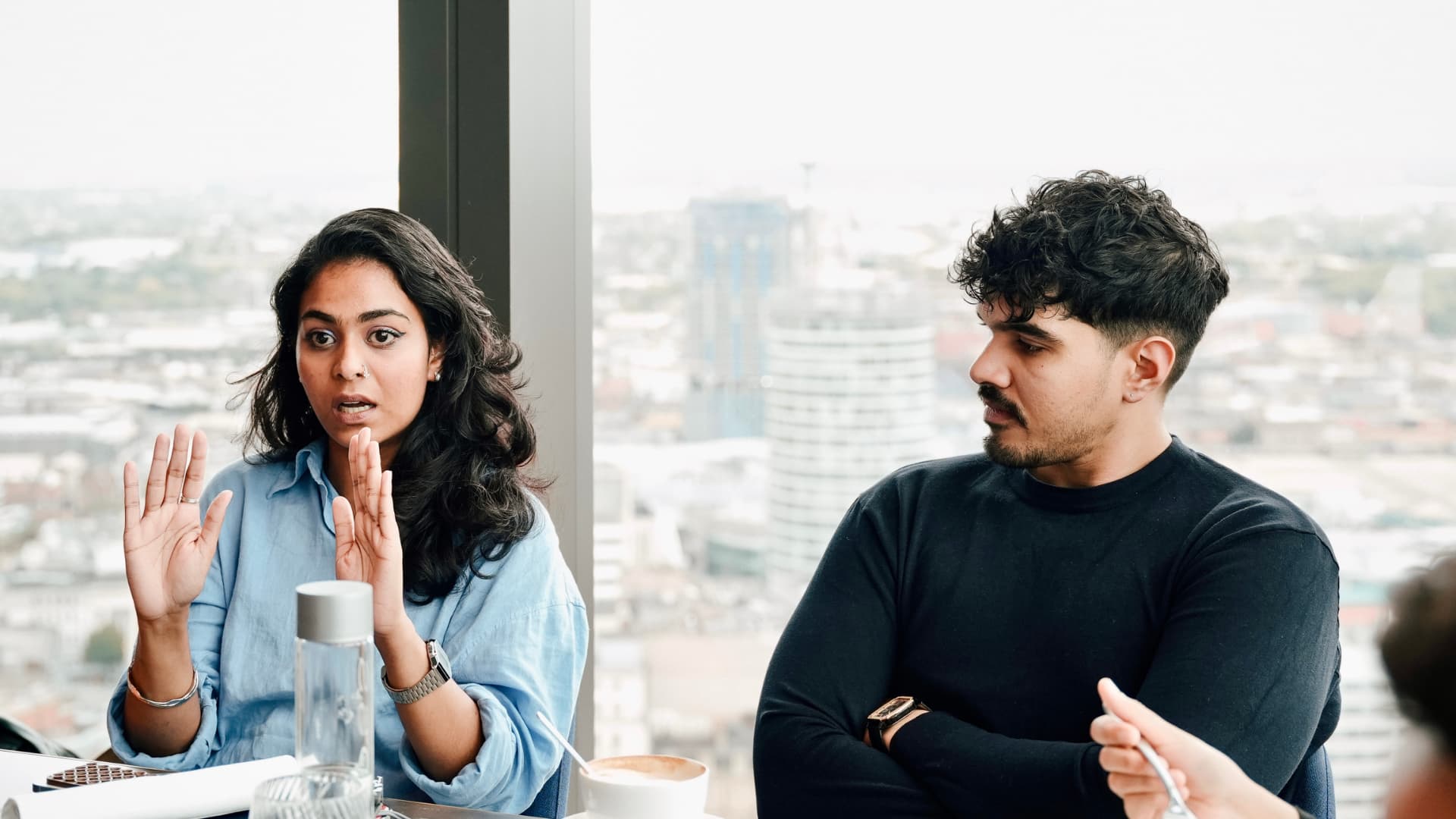 Two members in conversation by the window at a meetup